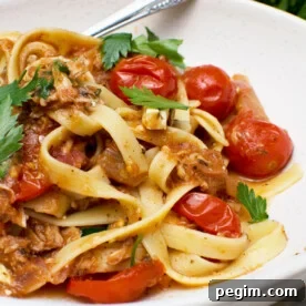 A close-up of lemony tuna spaghetti with a fork in it