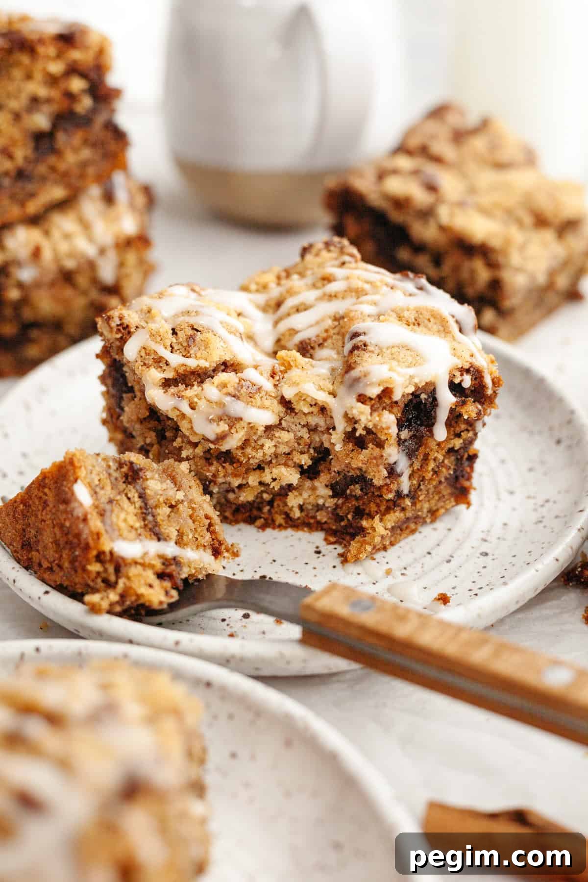 A slice of banana bread coffee cake drizzled with a white glaze on a small plate.