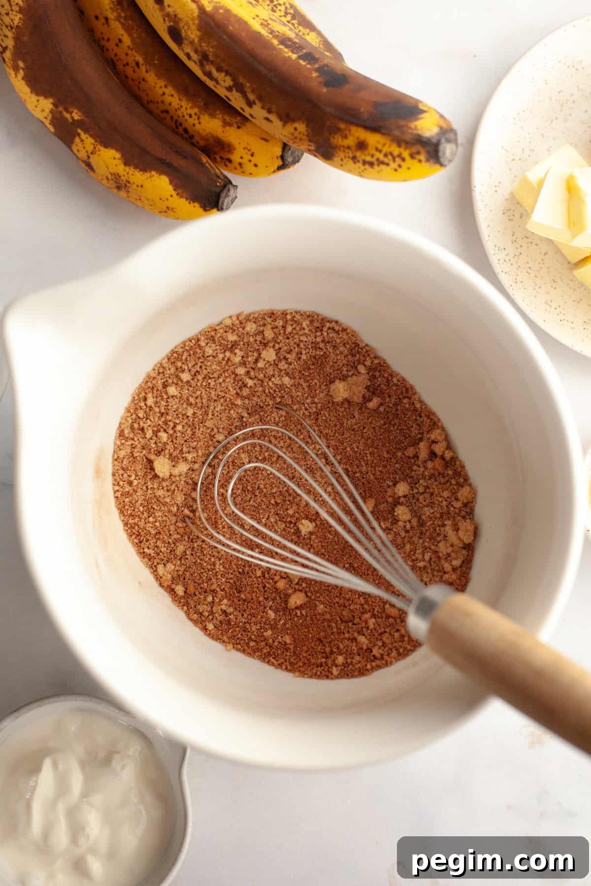 A large white bowl with cinnamon and brown sugar in it.