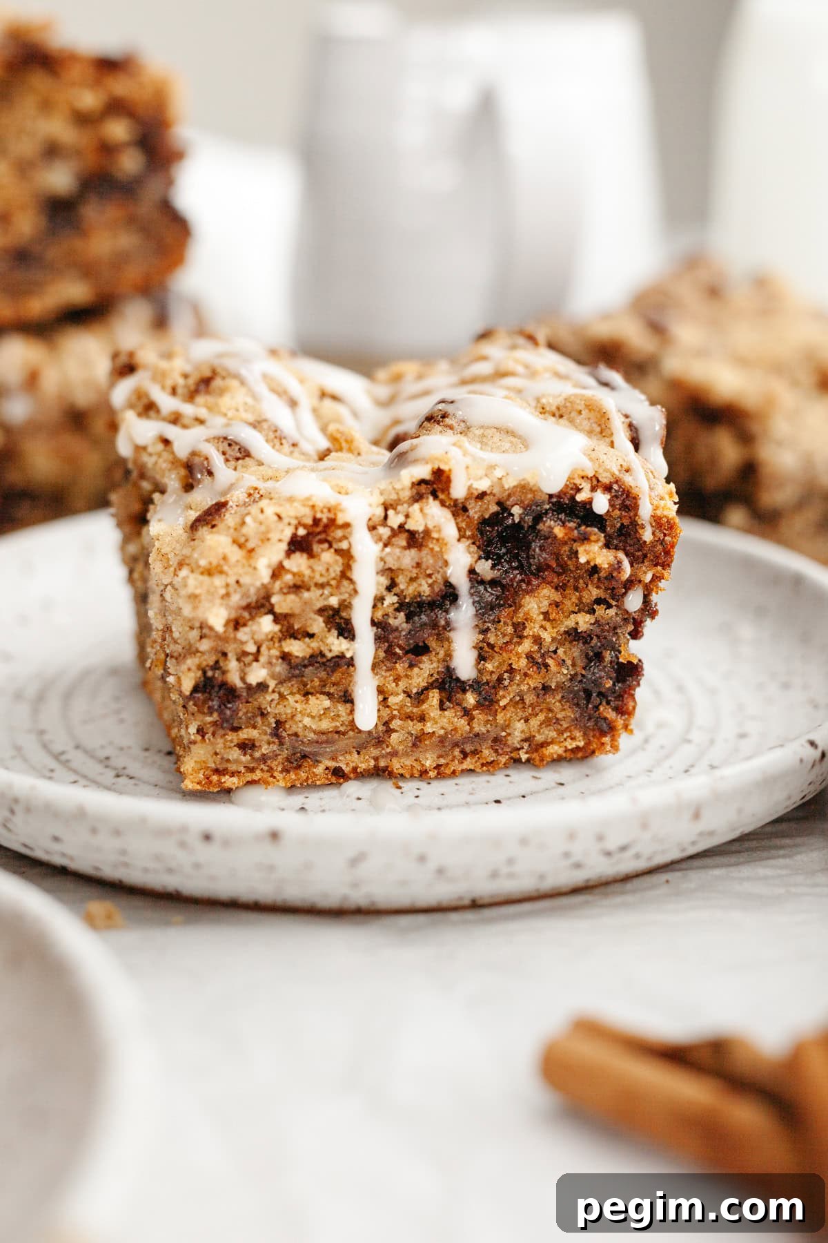A slice of banana bread coffee cake drizzled with a white glaze on a small plate.