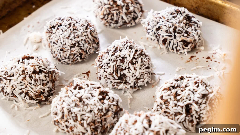 Newfoundland snowball cookies lined up on a parchment lined cookie sheet.