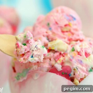 Close up of a spoon with a bite of Circus Animal No-Churn Ice Cream in a chocolate bowl.