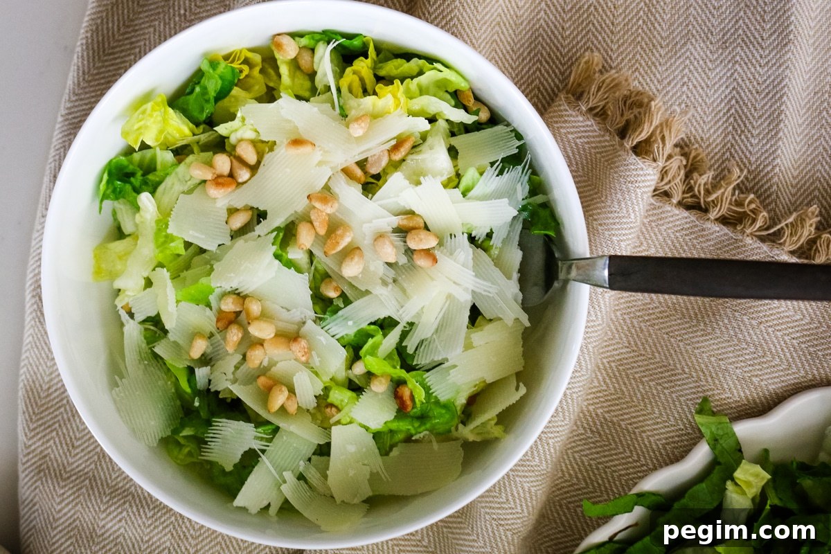 Romaine salad in a white bowl with a fork in it.