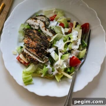 ranch chicken on crispy salad on a white plate.