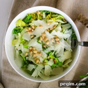 Romaine salad in a white bowl with a fork in it.