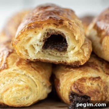 Eaten chocolate croissant stacked on other croissants.