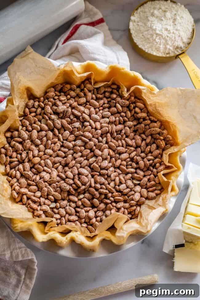 raw pie dough in a pan with beans as weights.