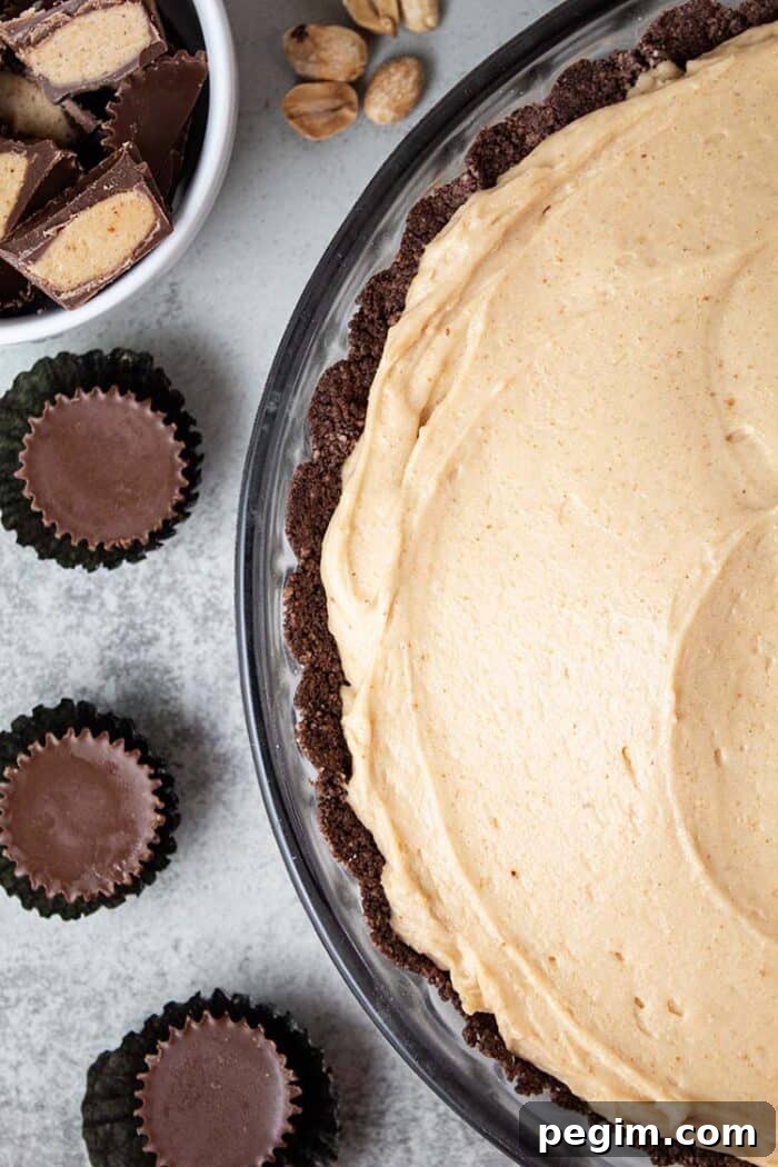 overhead view of keto peanut butter pie in a glass pie dish and 3 sugar free reese's mini cups next to it