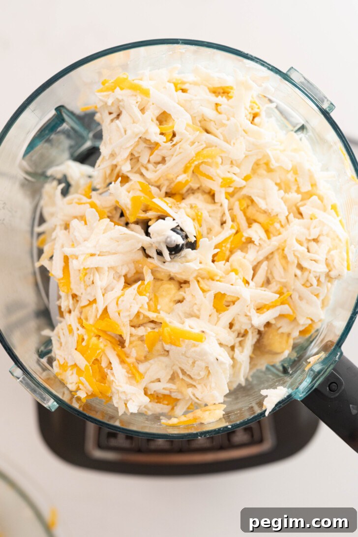 Grated masa ingredients in a food processor.