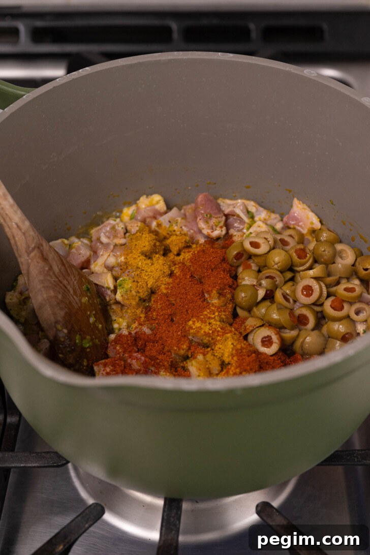 Chicken with spices and olives in a pot.