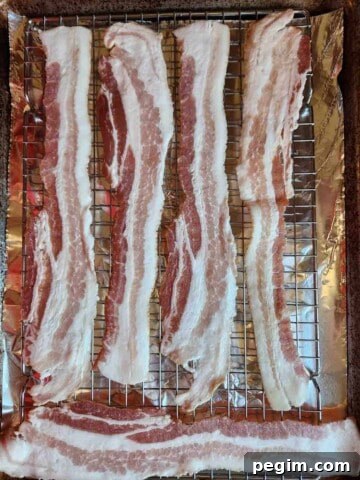 Raw bacon on a baking sheet.