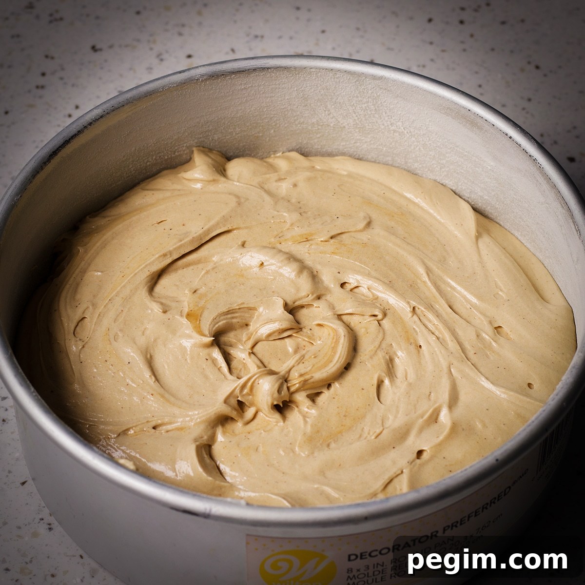 A cake pan filled with brown butter cake batter, ready to bake.