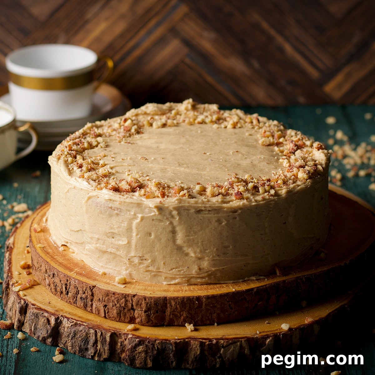 A brown butter cake frosted with maple miso brown butter frosting and sprinkled with chopped roasted almonds.
