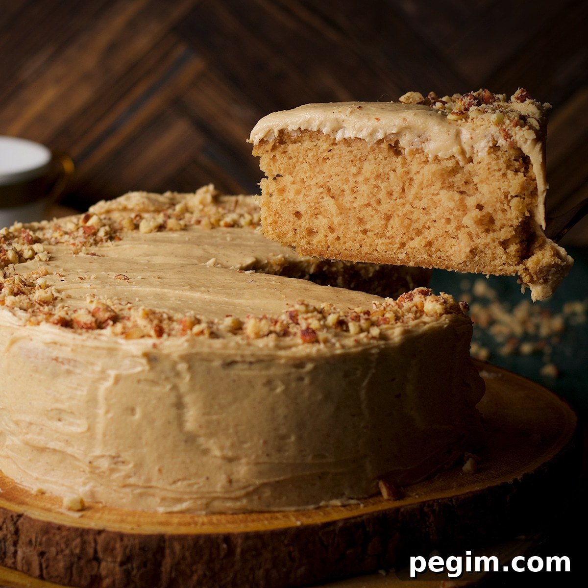 Someone using a cake server to lift a slice from brown butter cake.