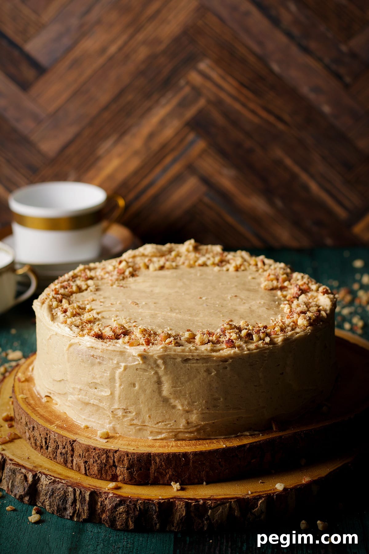 A brown butter cake frosted with maple miso brown butter frosting and sprinkled with chopped roasted almonds.