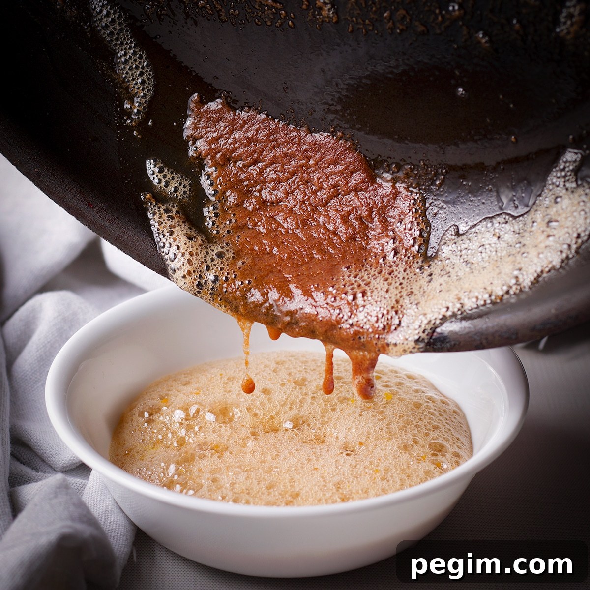 Toasted milk solids at the bottom of a skillet after pouring out the brown butter.
