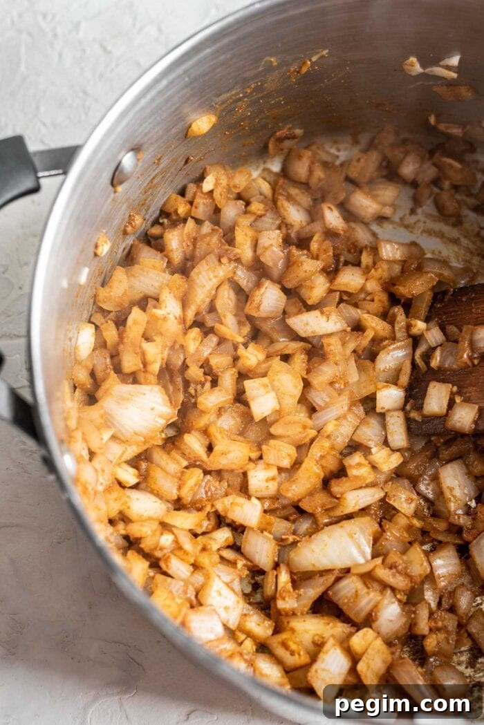 Chopped onions and garlic cooking in a large soup pot.