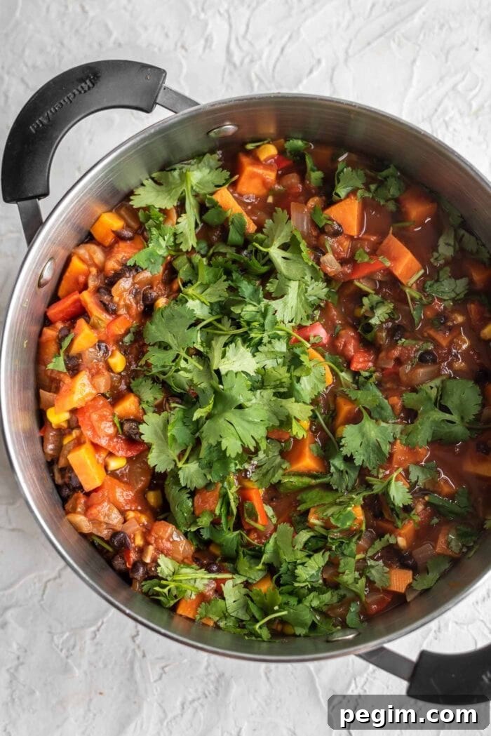 Sweet potato chili in a large soup pot topped with fresh, chopped cilantro.