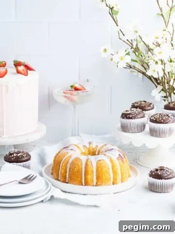 a selection of layer cakes, bundt cakes and cupcakes in front of a white tile backdrop
