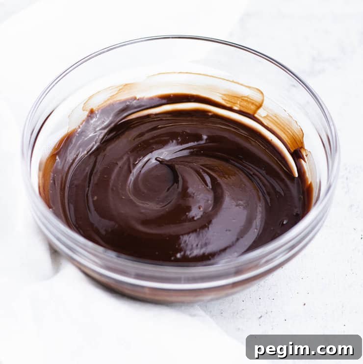 Chocolate ganache in a clear bowl cooled so that it holds a swirl.