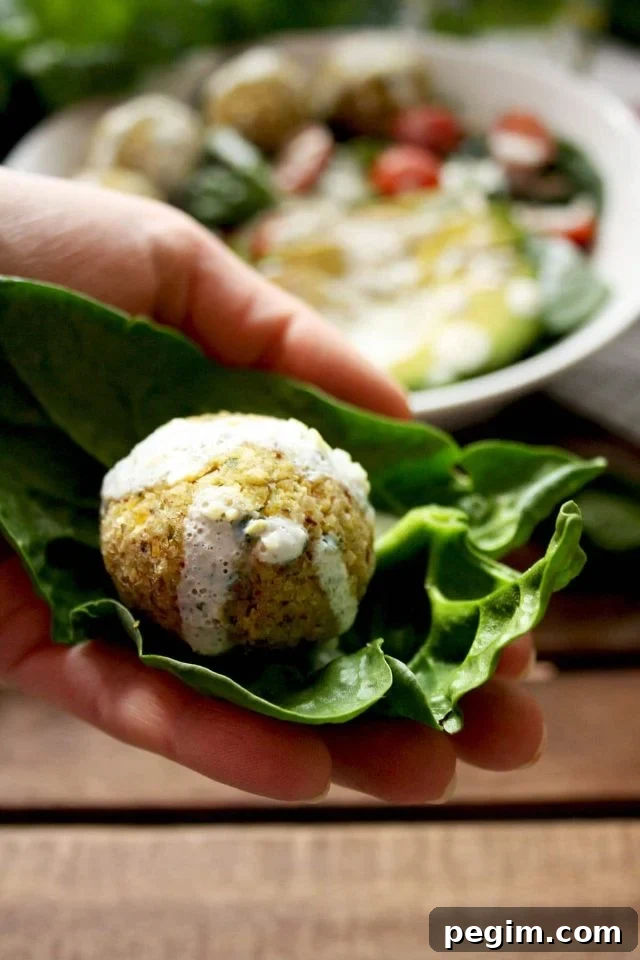 Crispy Baked Falafel with Hazelnuts and Creamy Lemon-Mint Sauce - Holding One in Hand