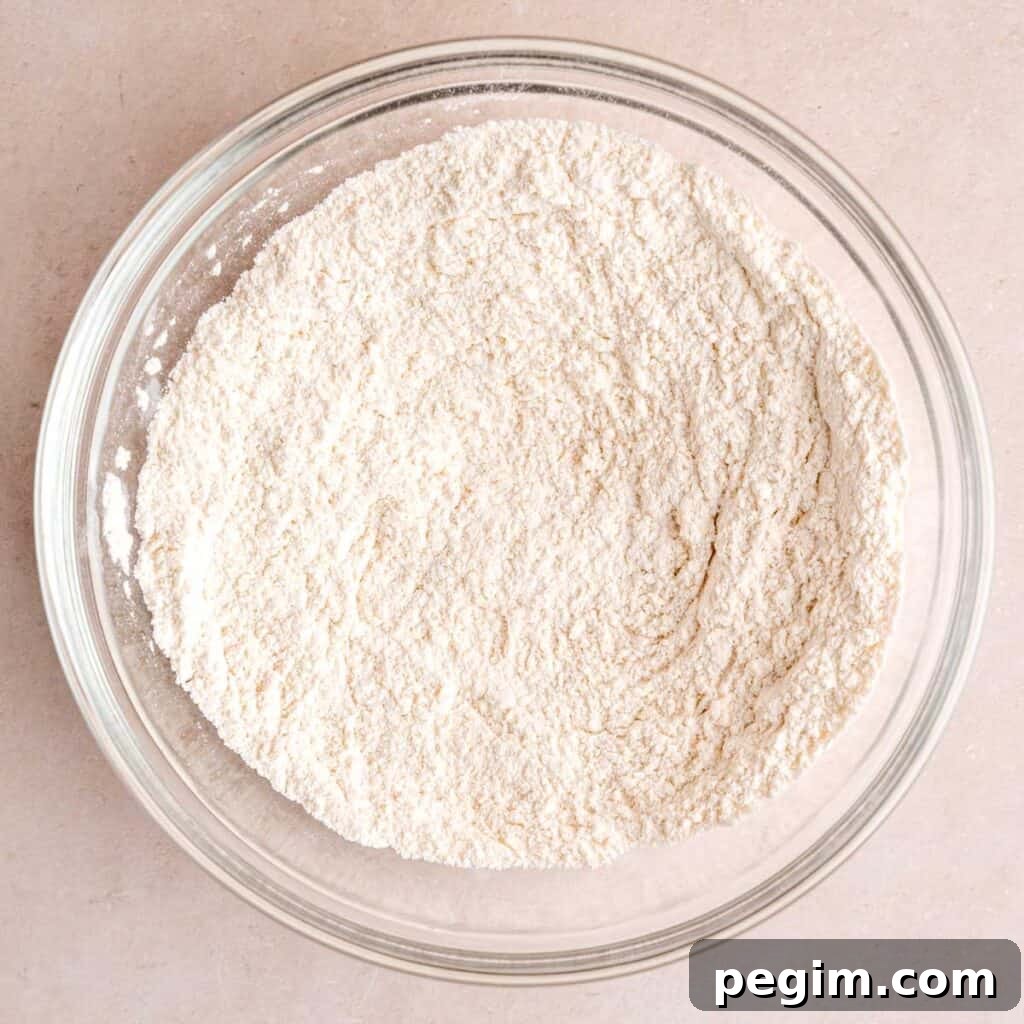 Flour, baking soda, baking powder, and salt mixed together in a bowl.