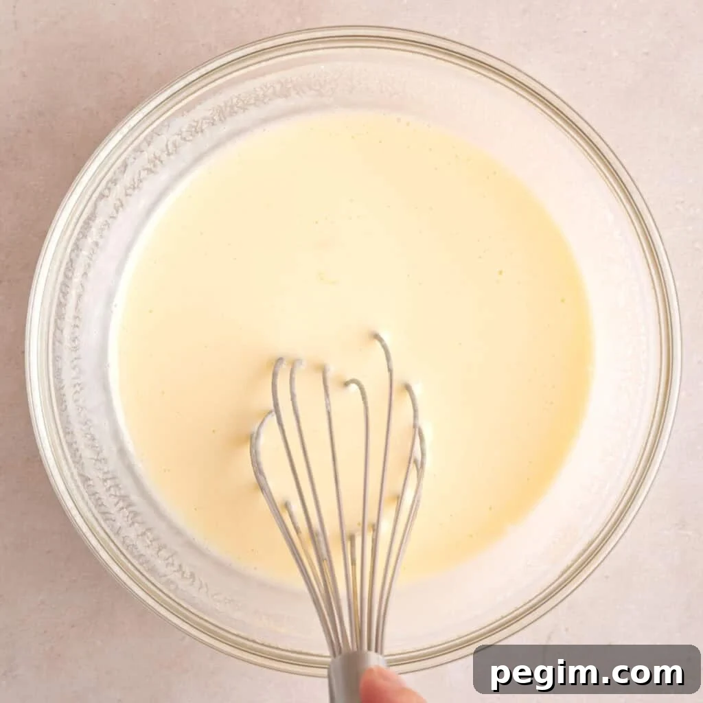 Whisking an egg, kefir, and maple syrup in a bowl.