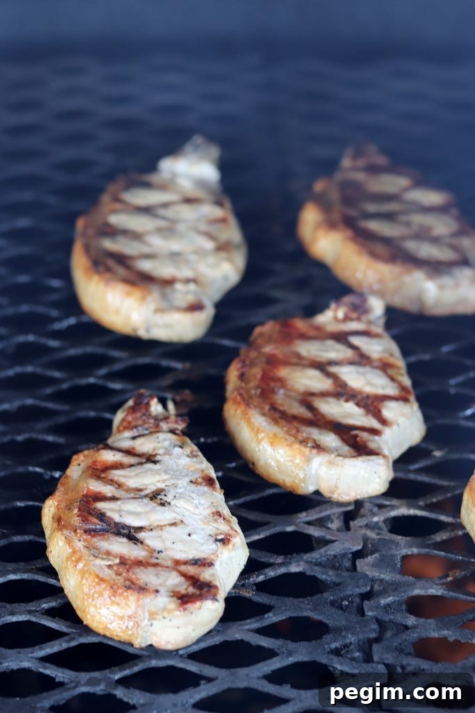 Boneless Pork Chops on the grill with grill marks on the pork chops