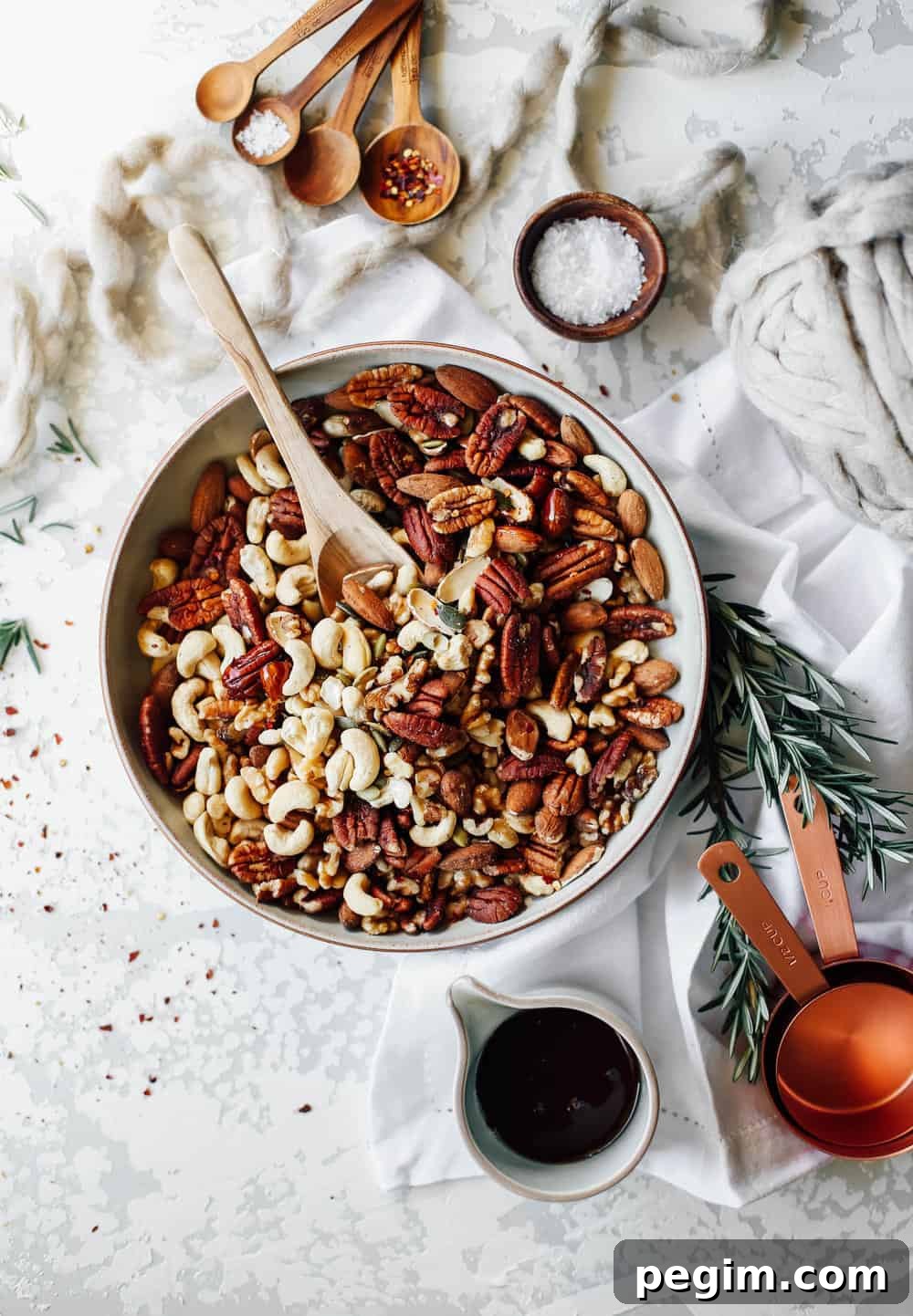 Large bowl of nuts with a wooden spoon. 