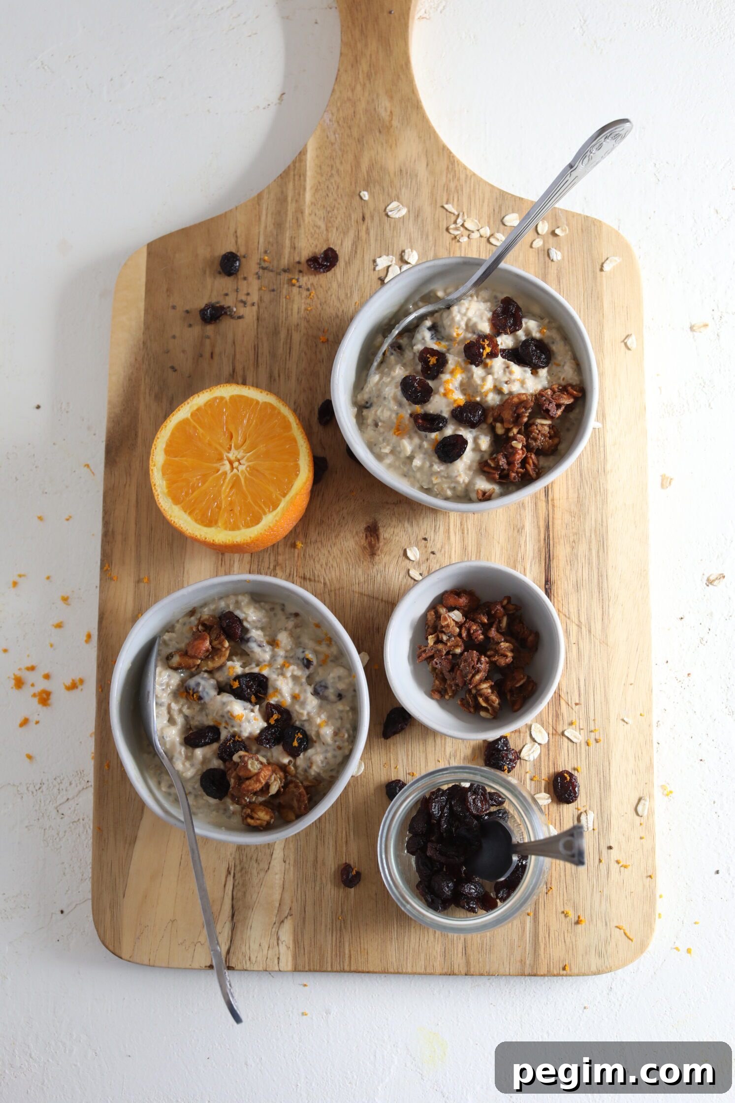 Orange Cranberry Overnight Oats served on wooden board by Flora & Vino
