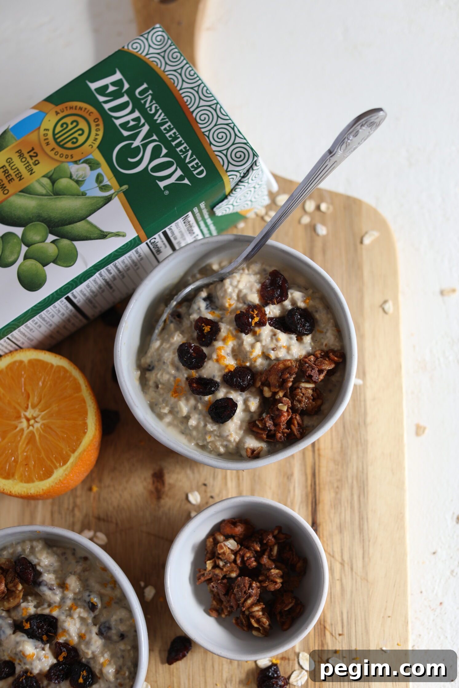 Orange Cranberry Overnight Oats served on wooden board by Flora & Vino