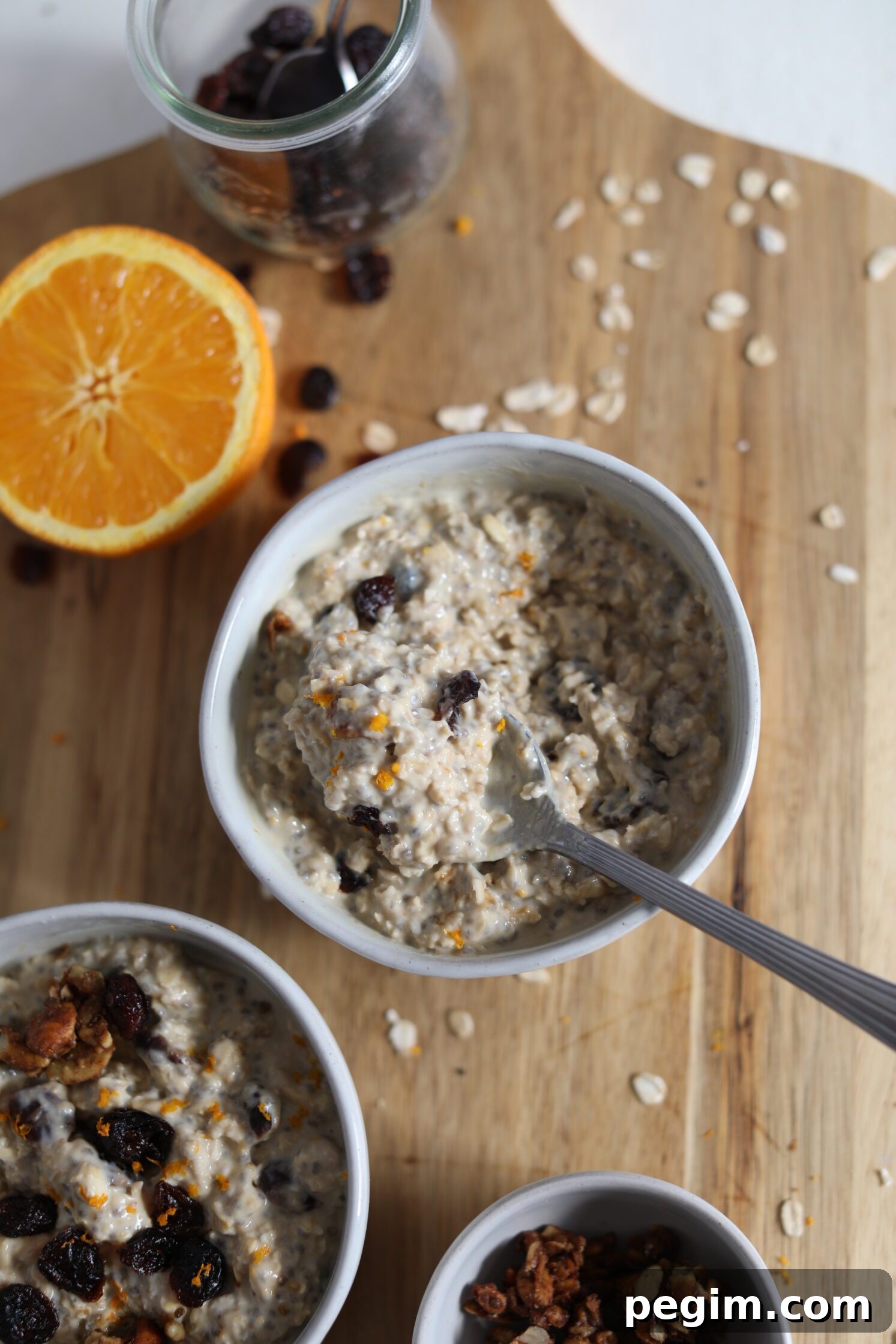 Orange Cranberry Overnight Oats served in bowls with spoon by Flora & Vino