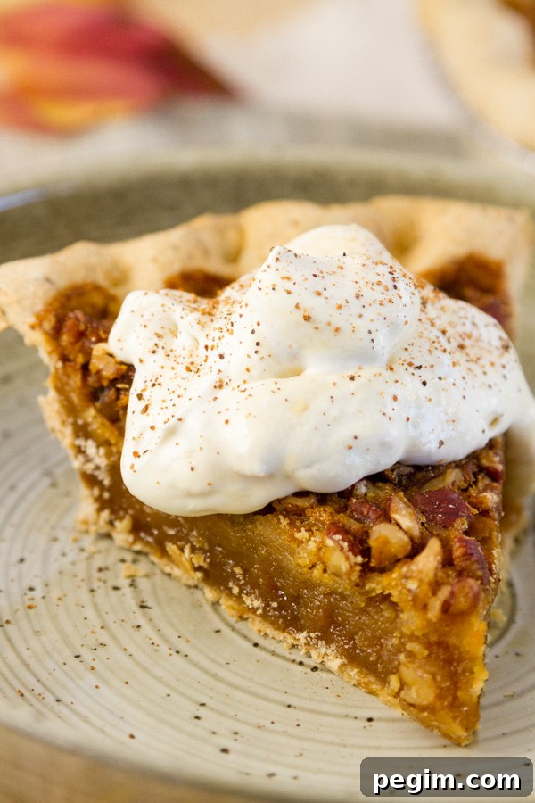 American Bourbon Pecan Pie from Millican Pecan Company with peach whipped cream on a plate with fall leaves in the background