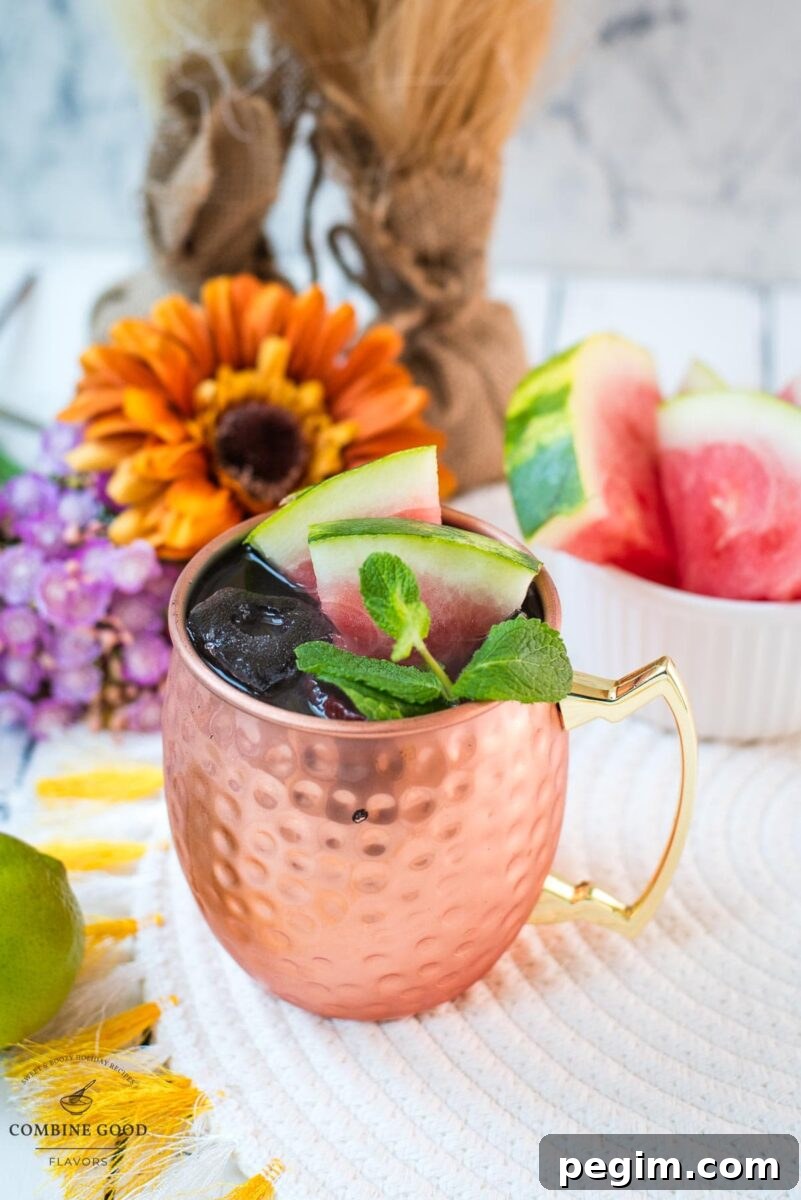 Gorgeous copper mug, filled with a delicious watermelon Moscow mule. Garnished with watermelon slices and mint leaves.