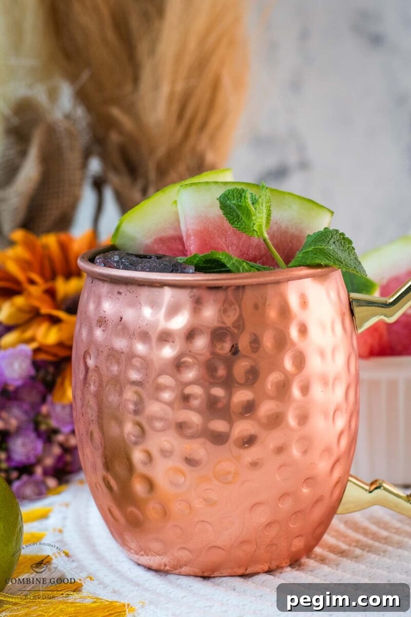 Gorgeous copper mug, filled with a delicious watermelon Moscow mule. Garnished with watermelon slices and mint leaves.