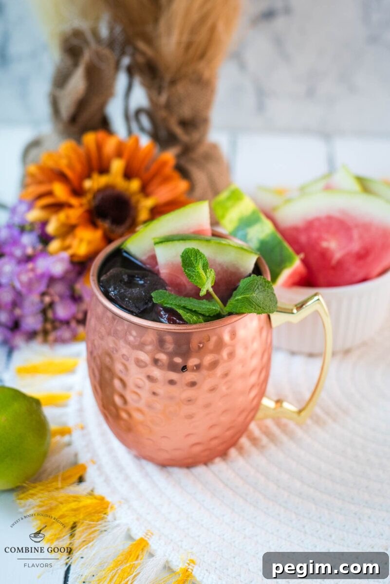 Gorgeous copper mug, filled with a delicious watermelon Moscow mule. Garnished with watermelon slices and mint leaves.