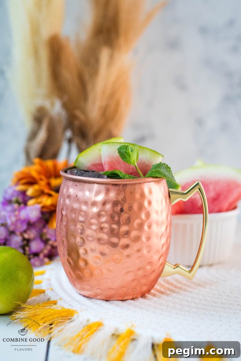 Gorgeous copper mug, filled with a delicious watermelon Moscow mule. Garnished with watermelon slices and mint leaves.