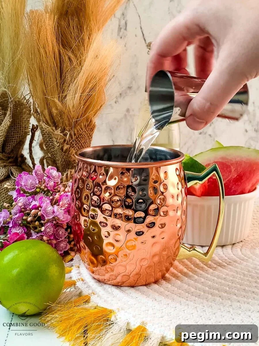Adding vanilla vodka to the copper mug.