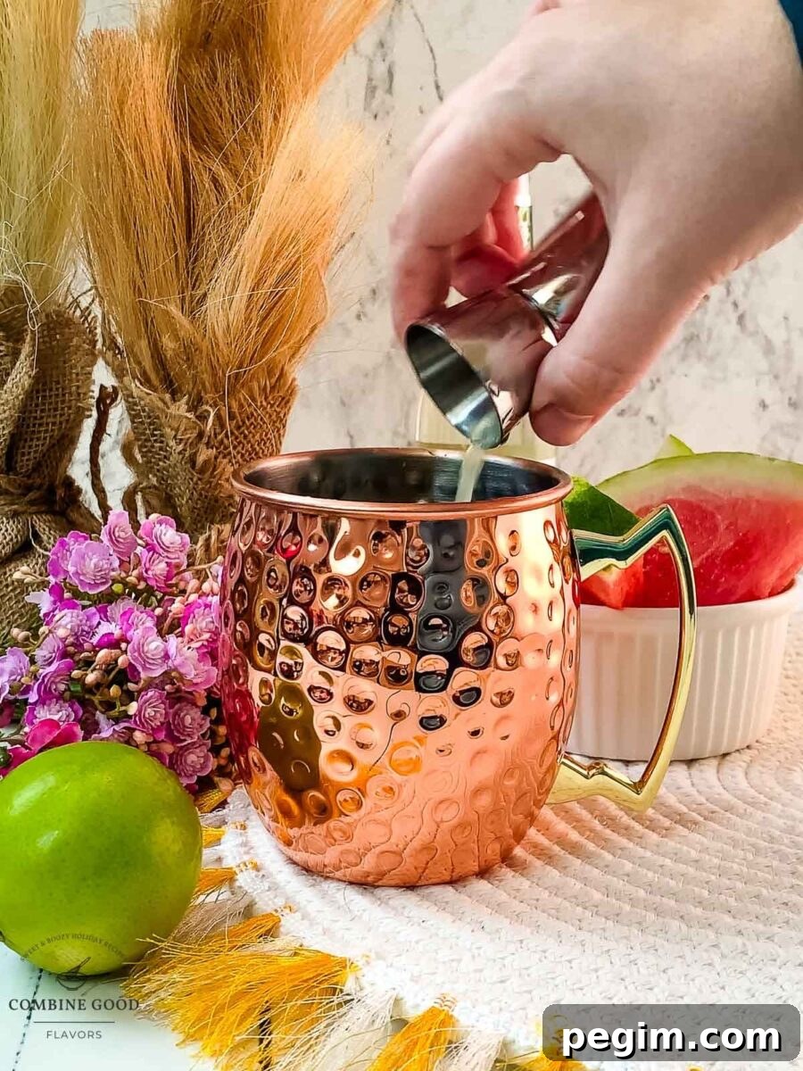 Adding lime juice to the copper mug.