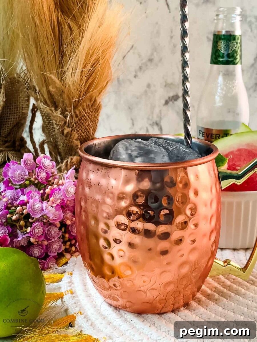 Stirring the watermelon Moscow mule, using a bar spoon.