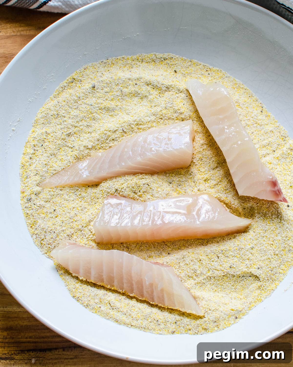 dredging the fish with the cornmeal.