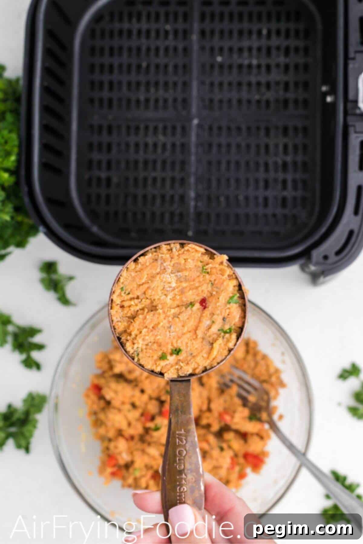 Salmon mixture in a measuring cup before being shaped into a patty and air fried.
