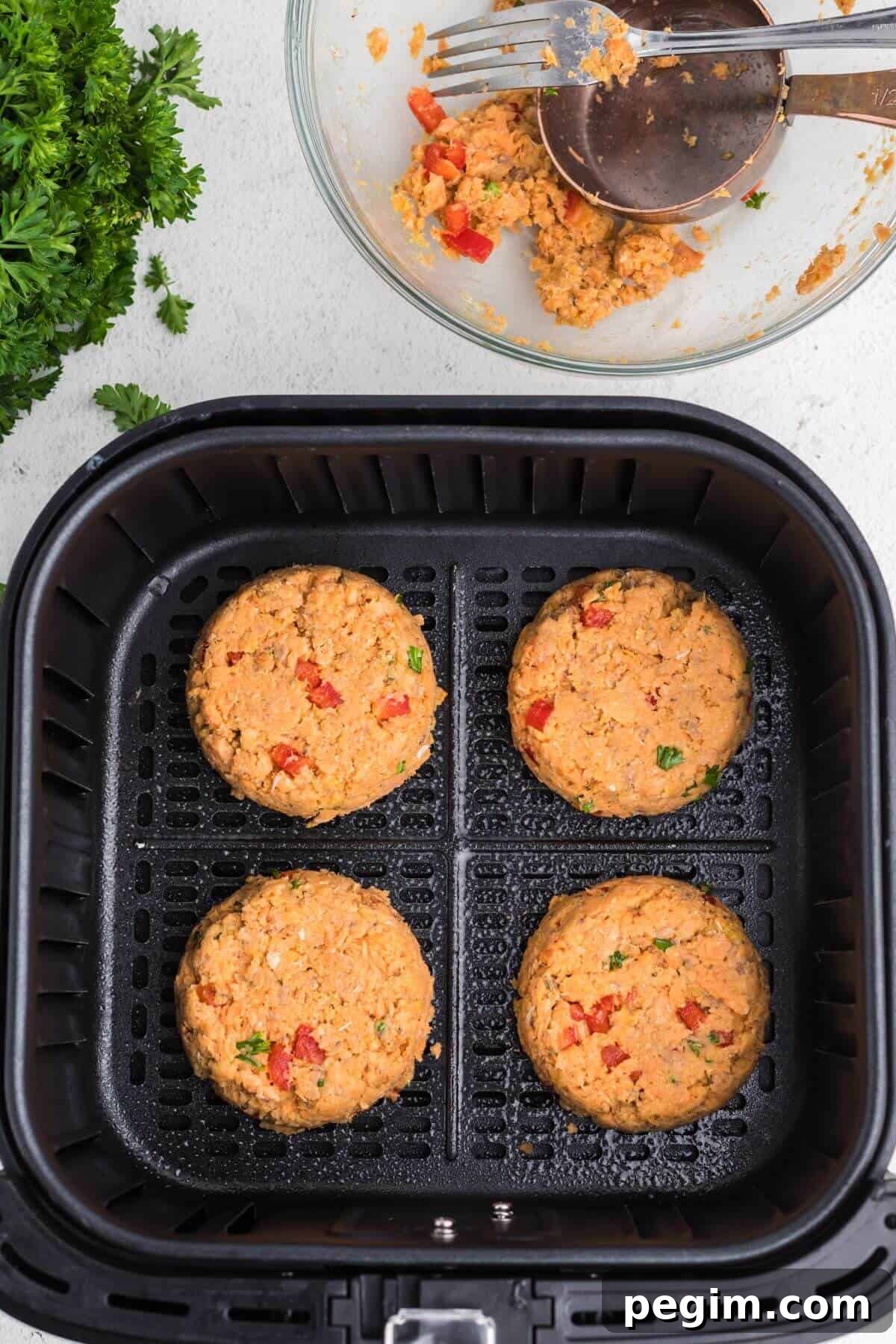 Shaped patties in the air fryer basket ready to cook.