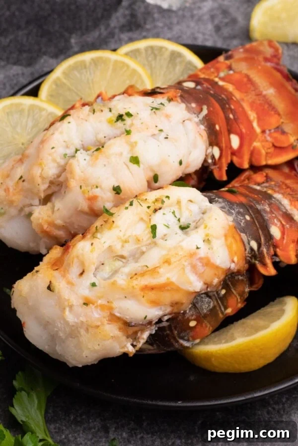 Air fryer lobster tails garnished with lemon on a plate.