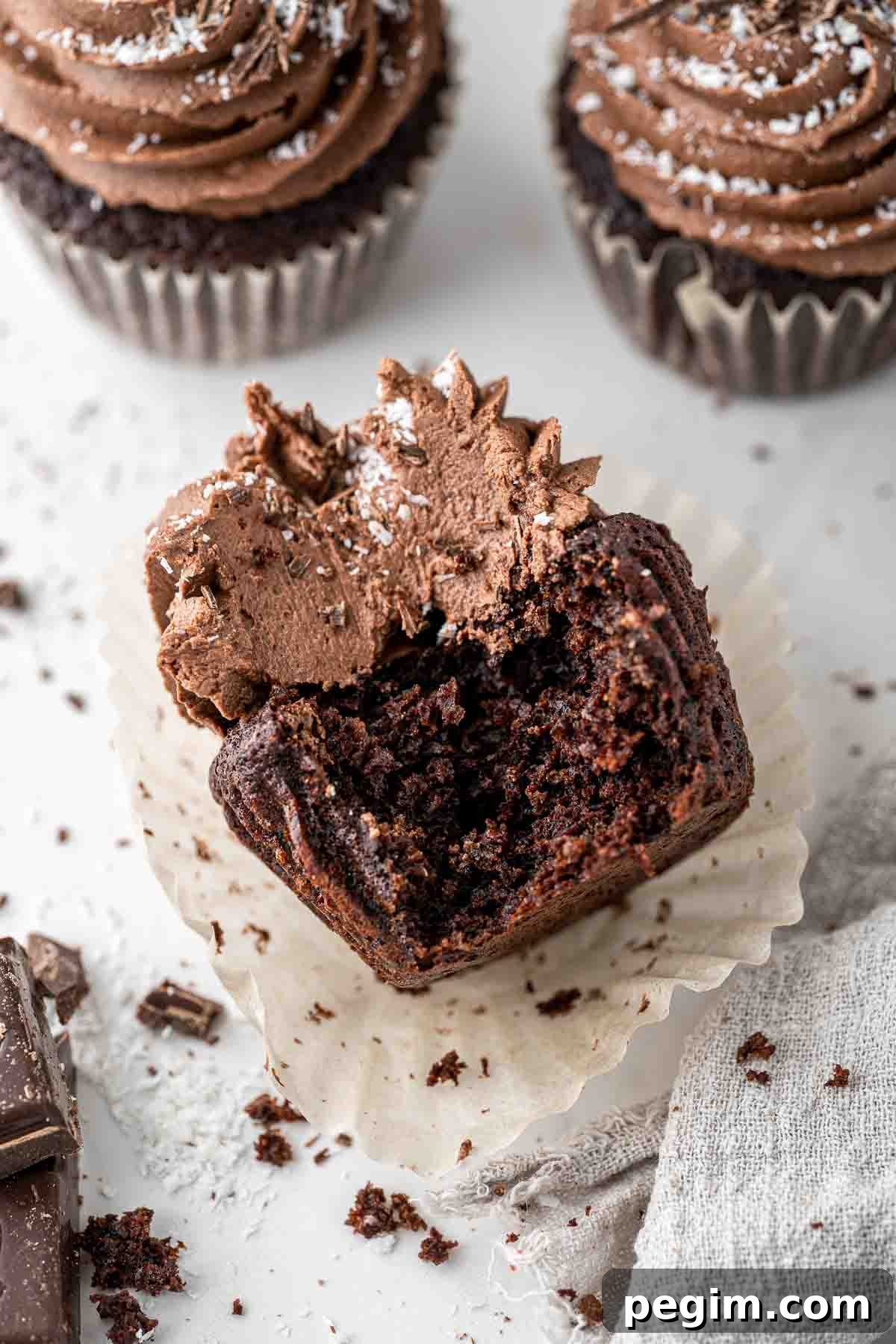 Close up of a chocolate and coconut cupcake with a bite taken.