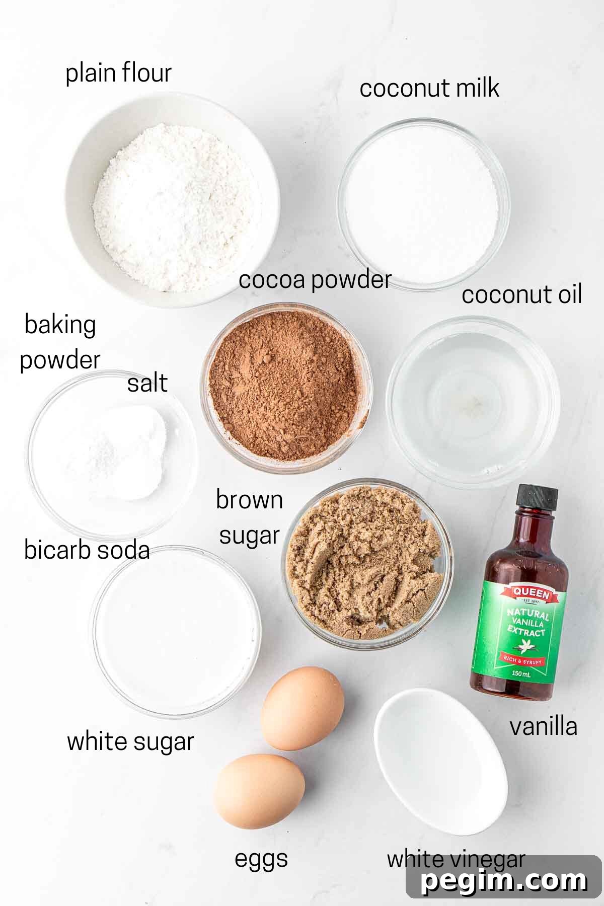 All ingredients needed for chocolate and coconut cupcakes laid out in small bowls.