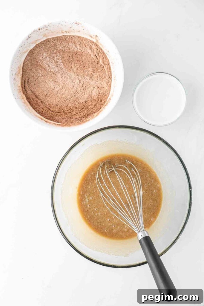Step 1 of making the batter - ingredients being mixed together in a bowl with a whisk.