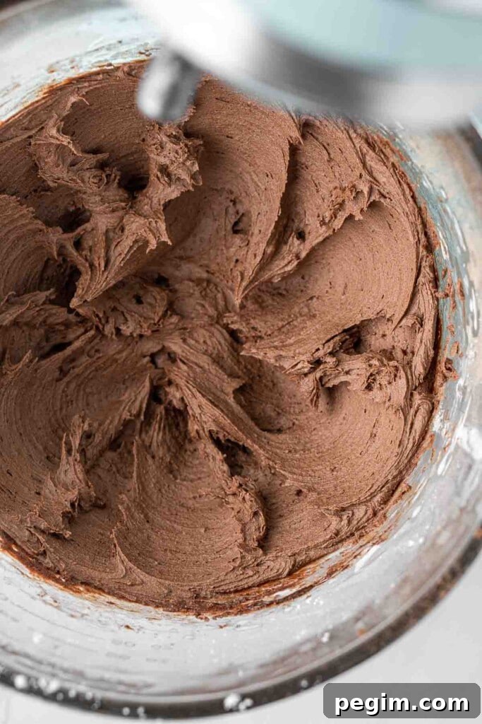 Close up of chocolate buttercream in the bowl of a stand mixer.