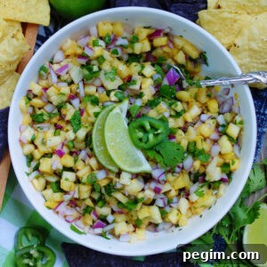 A bowl of fresh pineapple salsa ready to eat with tortilla chips as a dip
