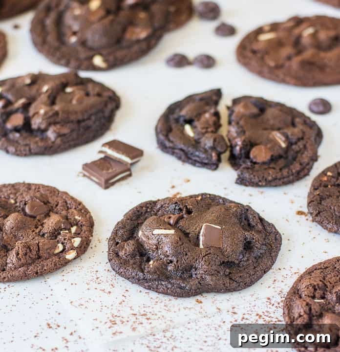 cookies scattered on a piece of parchment paper with Andes mints and chocolate chips